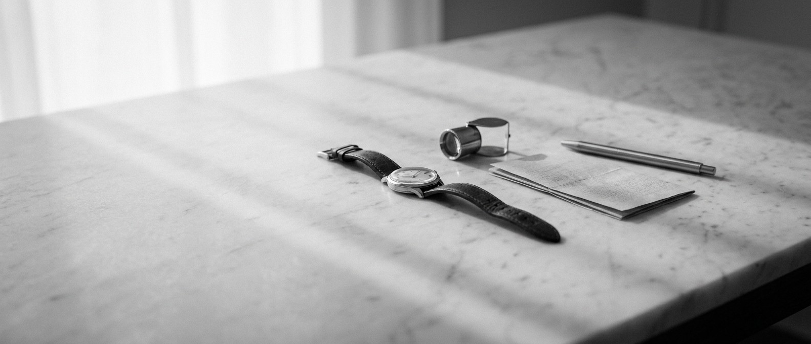 A perpetual calendar on a leather strap resting on documents